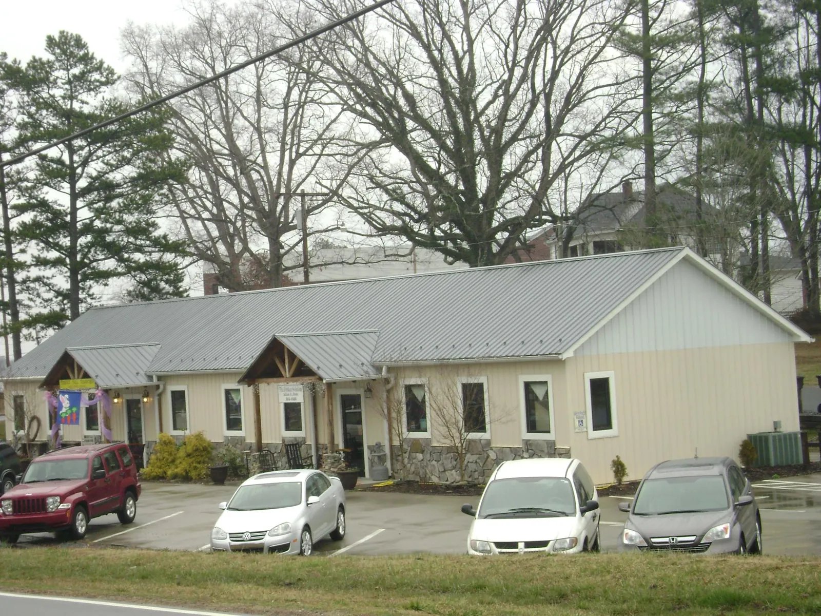 Gray metal roof with timber entry brackets on a small commercial building in Millville